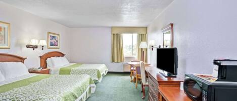 A hotel room with two beds, a desk, a television, and a microwave.