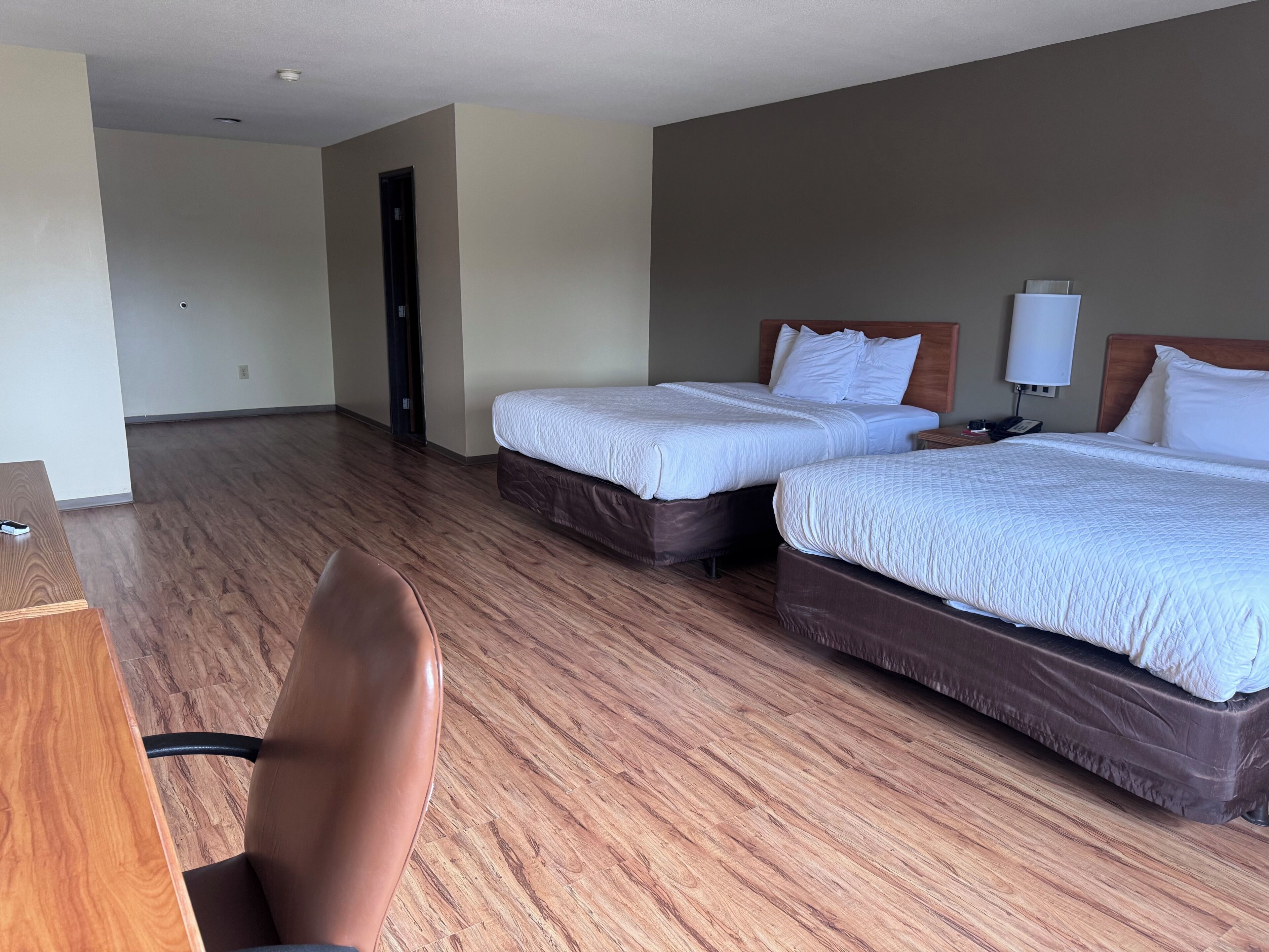 Una habitación de hotel con dos camas, un escritorio y una silla.