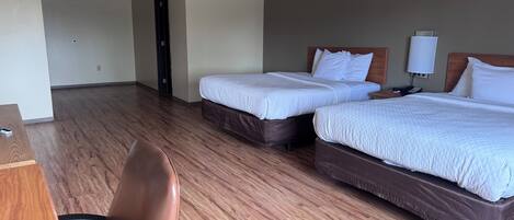 Una habitación de hotel con dos camas, un escritorio y una silla.
