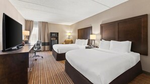 A hotel room with two beds, a desk with a flat-screen TV, a lamp, a chair, and a microwave. - Comfort Inn Lehigh Valley West - Allentown (Allentown)