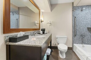 A modern bathroom with a granite countertop, a white toilet, a bathtub, and a shower with grab bars. - Comfort Inn Lehigh Valley West - Allentown (Allentown)