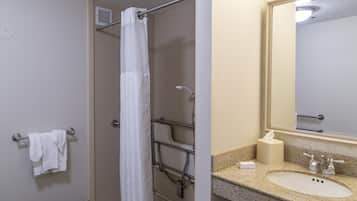 A bathroom with a shower, a towel rack, a sink, and a mirror.