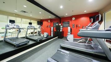 A fitness center with treadmills, a stationary bike, and a mirrored wall.