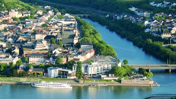 A riverside town with a prominent white cruise ship docked at the waterfront.