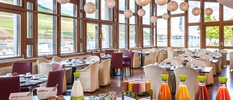 A spacious dining area with large windows, wooden beams, and hanging paper lanterns.
