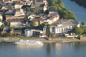 A riverfront hotel with a large building, a dock, and a river.
