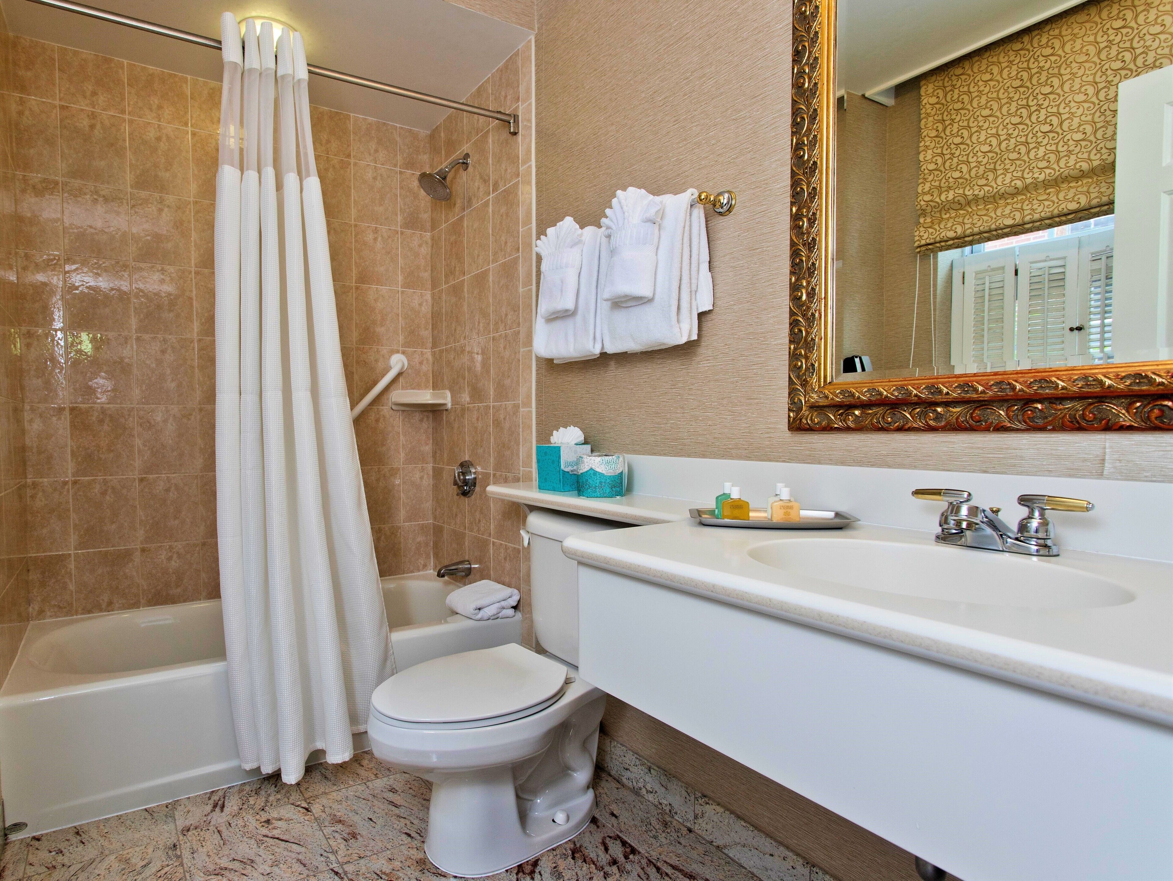 A bathroom with a bathtub, toilet, and sink.