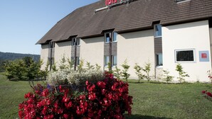 Un hotel con techo plano, varias ventanas y un cartel con la leyenda "ibis HOTEL" en el techo.