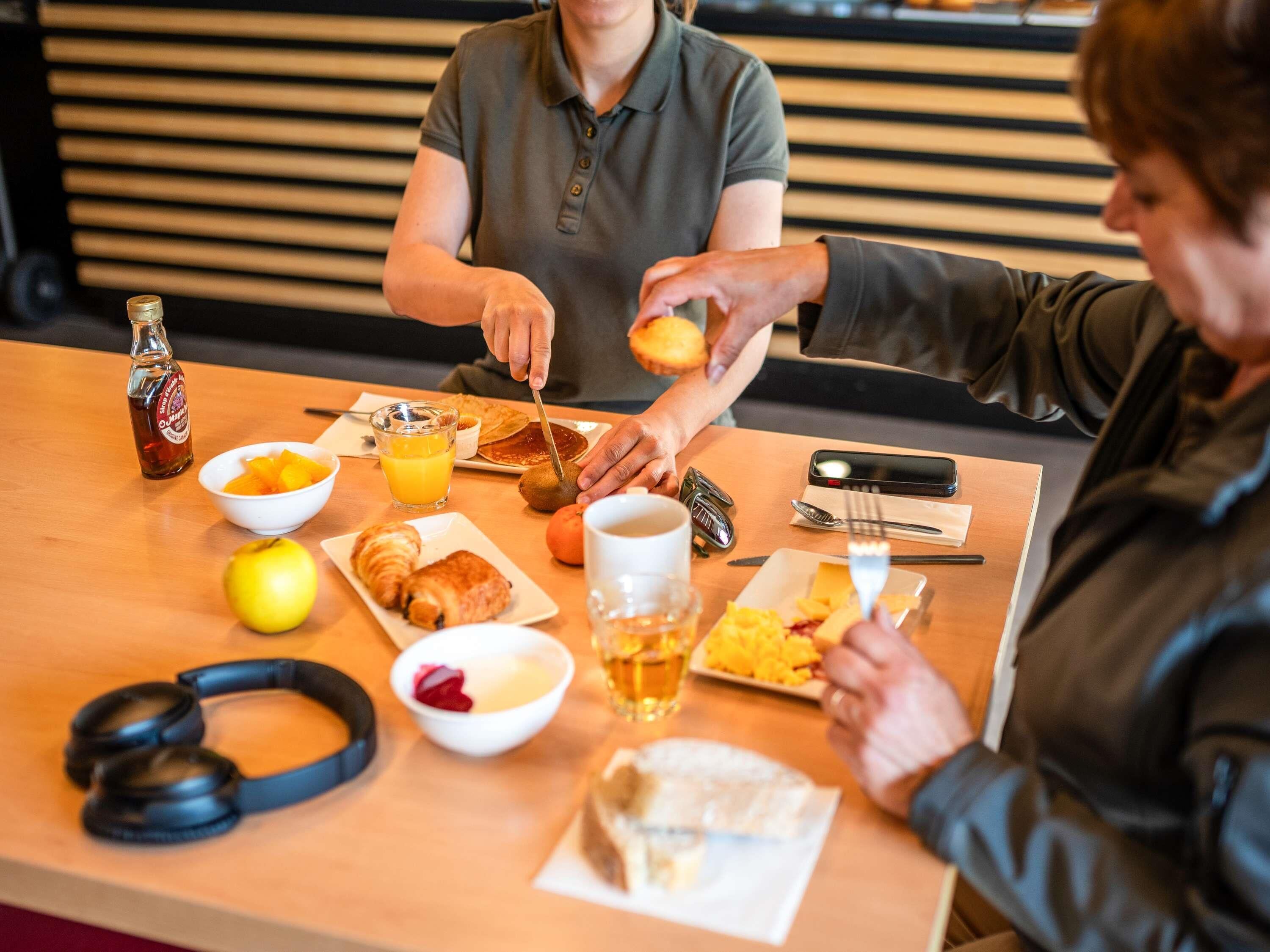 En frukostuppdukning med ett bord, mat och en flaska.