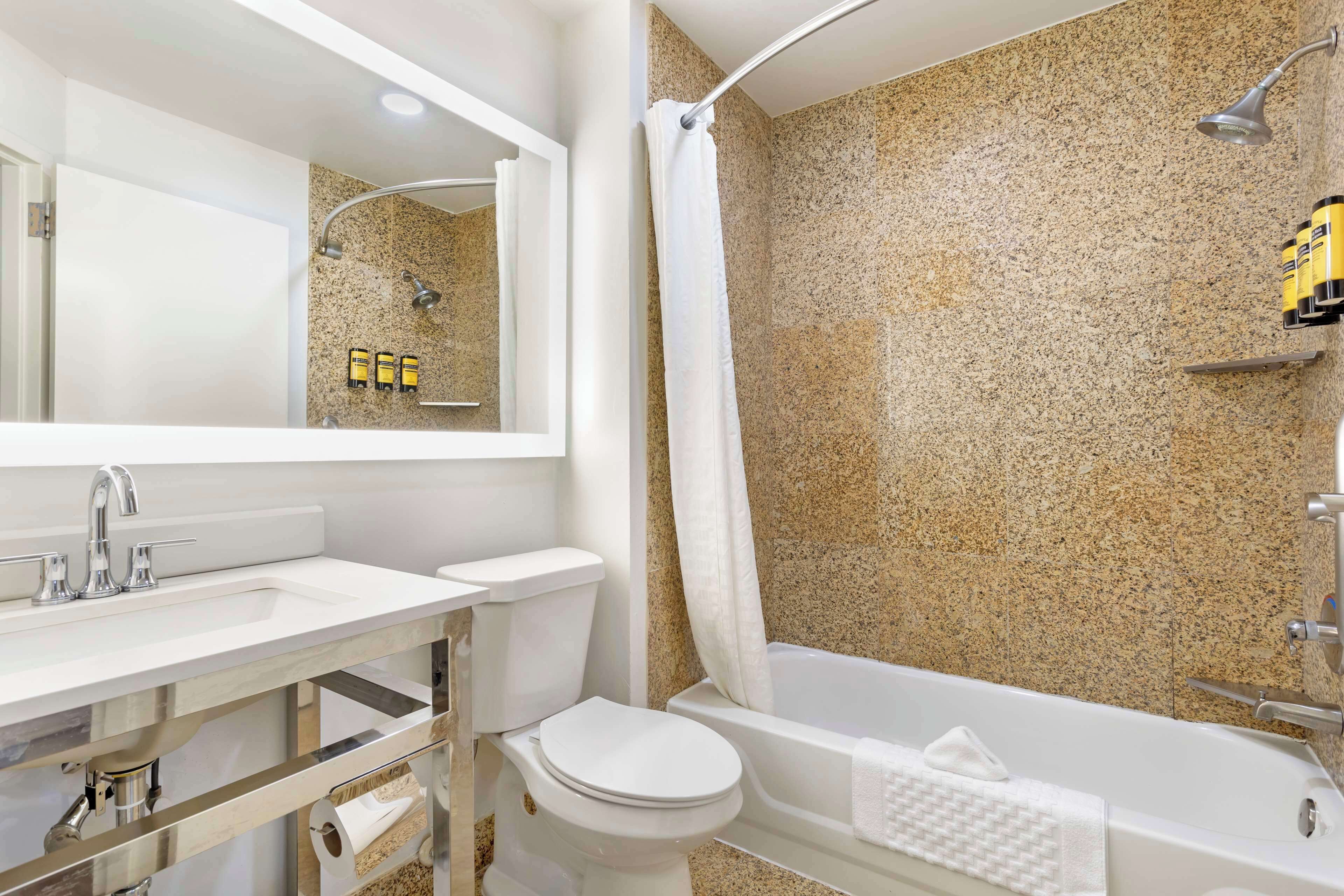 Une salle de bain avec un lavabo, des toilettes et une baignoire, le tout de couleur blanche.