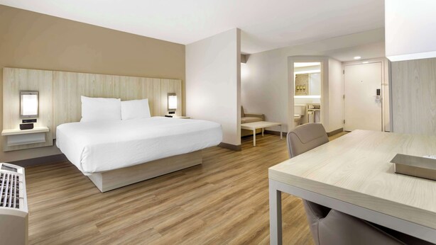 A modern hotel room with a large bed, bedside tables, a desk, and a chair. - Best Western Plus Sugar Land/Stafford (Sugar Land)