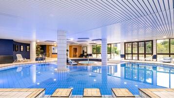 Una piscina techada, sillones reclinables de piscina