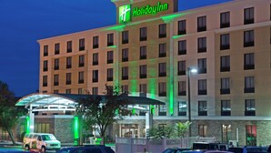 Un hôtel Holiday Inn doté d’une façade moderne, de plusieurs étages et d’une enseigne verte bien visible.