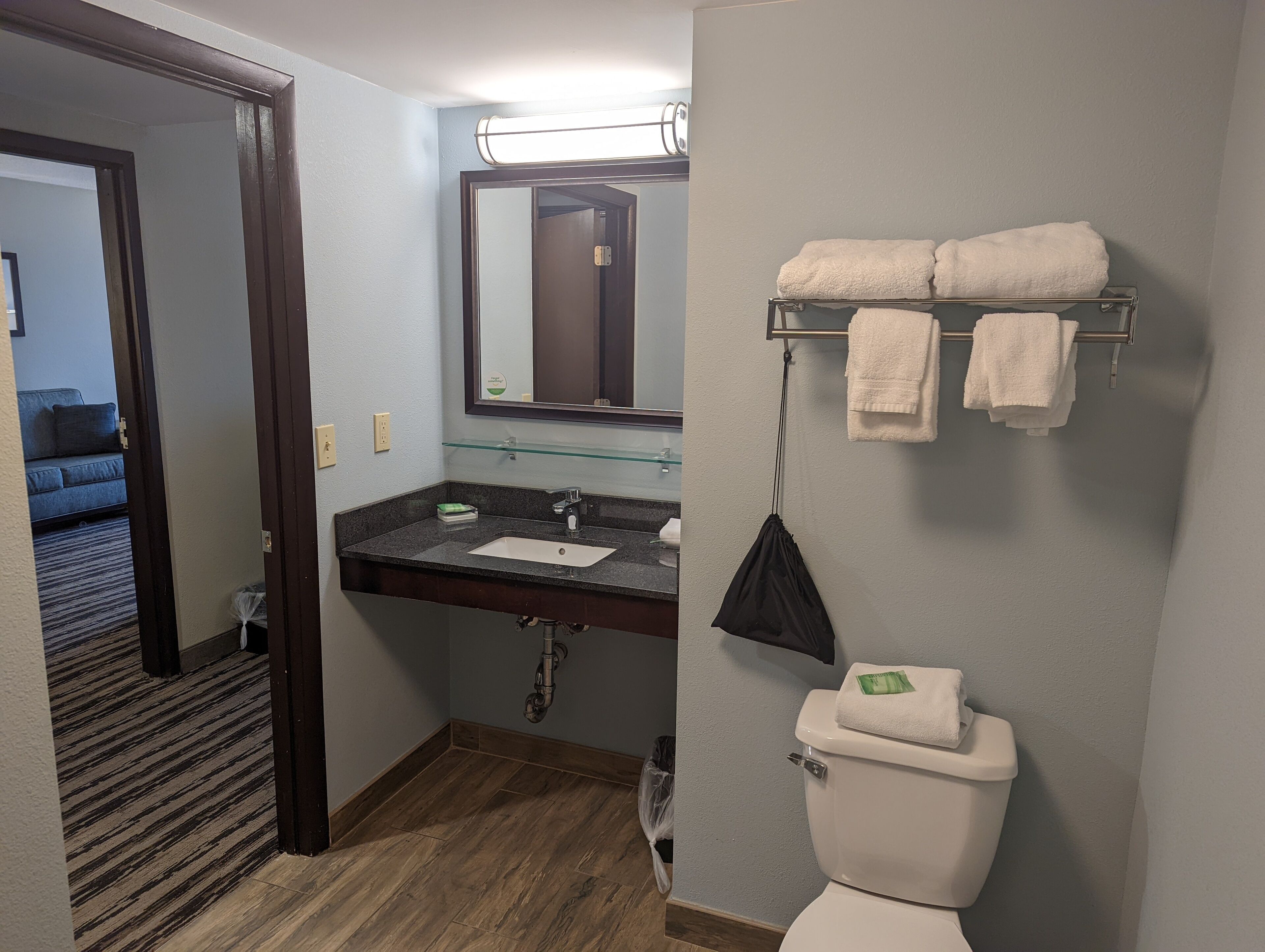 A bathroom with a sink, mirror, towel rack, and toilet.