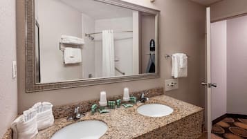 Un baño con dos lavamanos, un espejo grande y una zona de ducha.