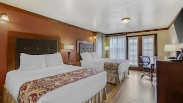 Habitación de hotel con dos camas, un escritorio y una silla.