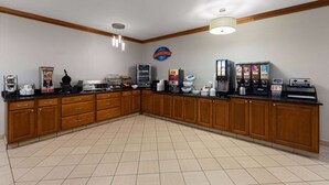 A spacious kitchen with wooden cabinets, a breakfast bar, and various appliances like a coffee maker and toaster.