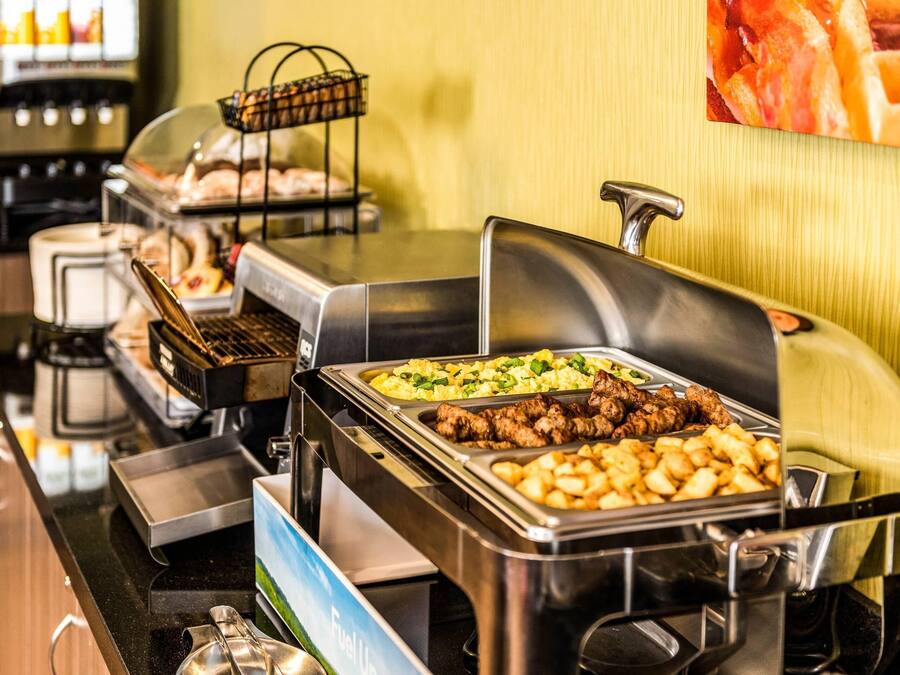 Un buffet proposant une variété de plats, notamment des viandes, des pommes de terre et des légumes.