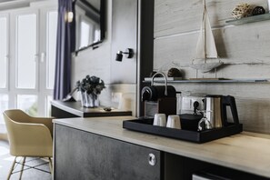 A modern kitchenette with a coffee machine, tea kettle, and a small shelf with decorative items. - Best Western Hotel Kurfürst Wilhelm I (Kassel)