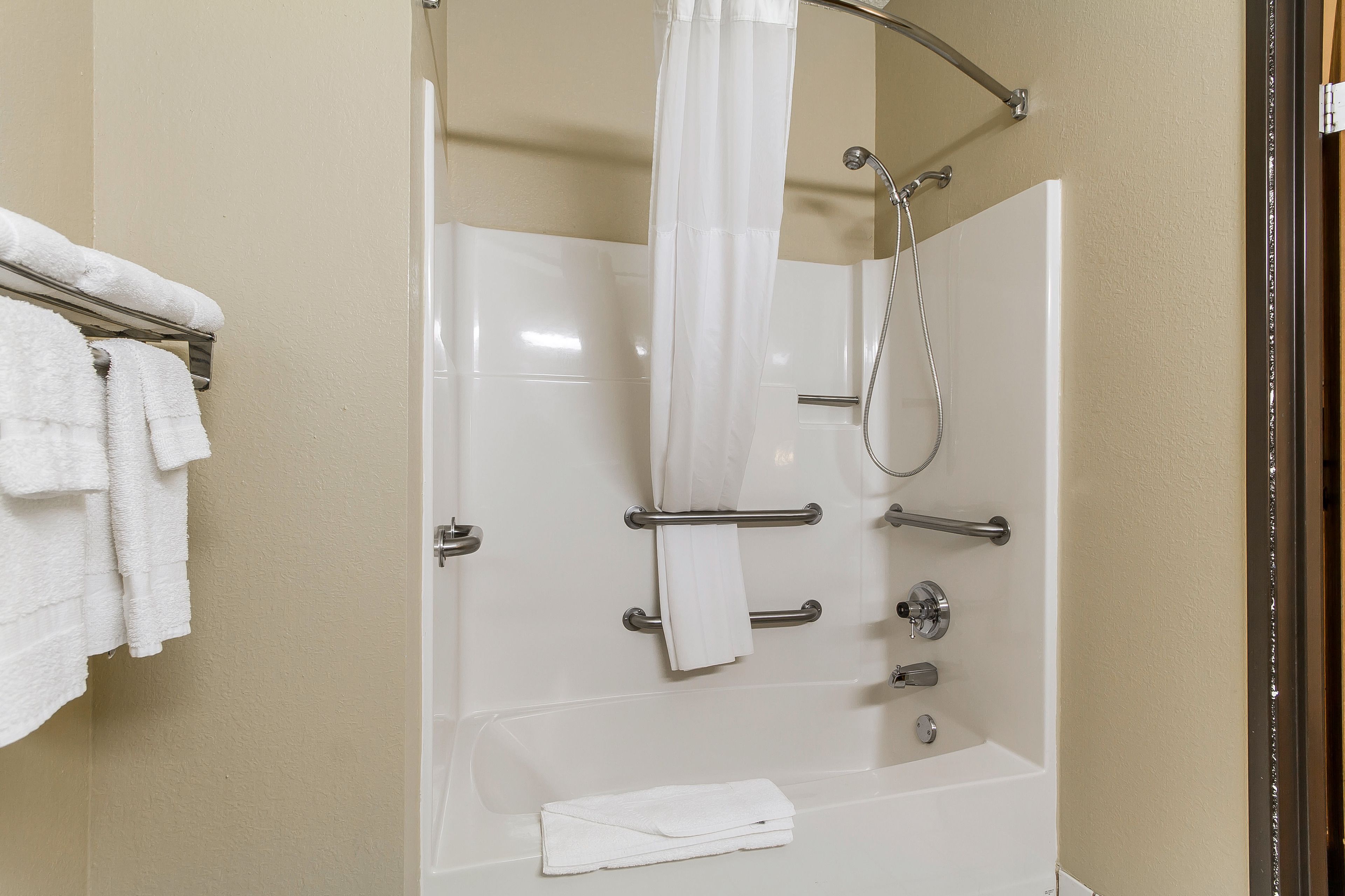 Une salle de bain moderne équipée d’une baignoire, d’une douche et d’un porte-serviettes.