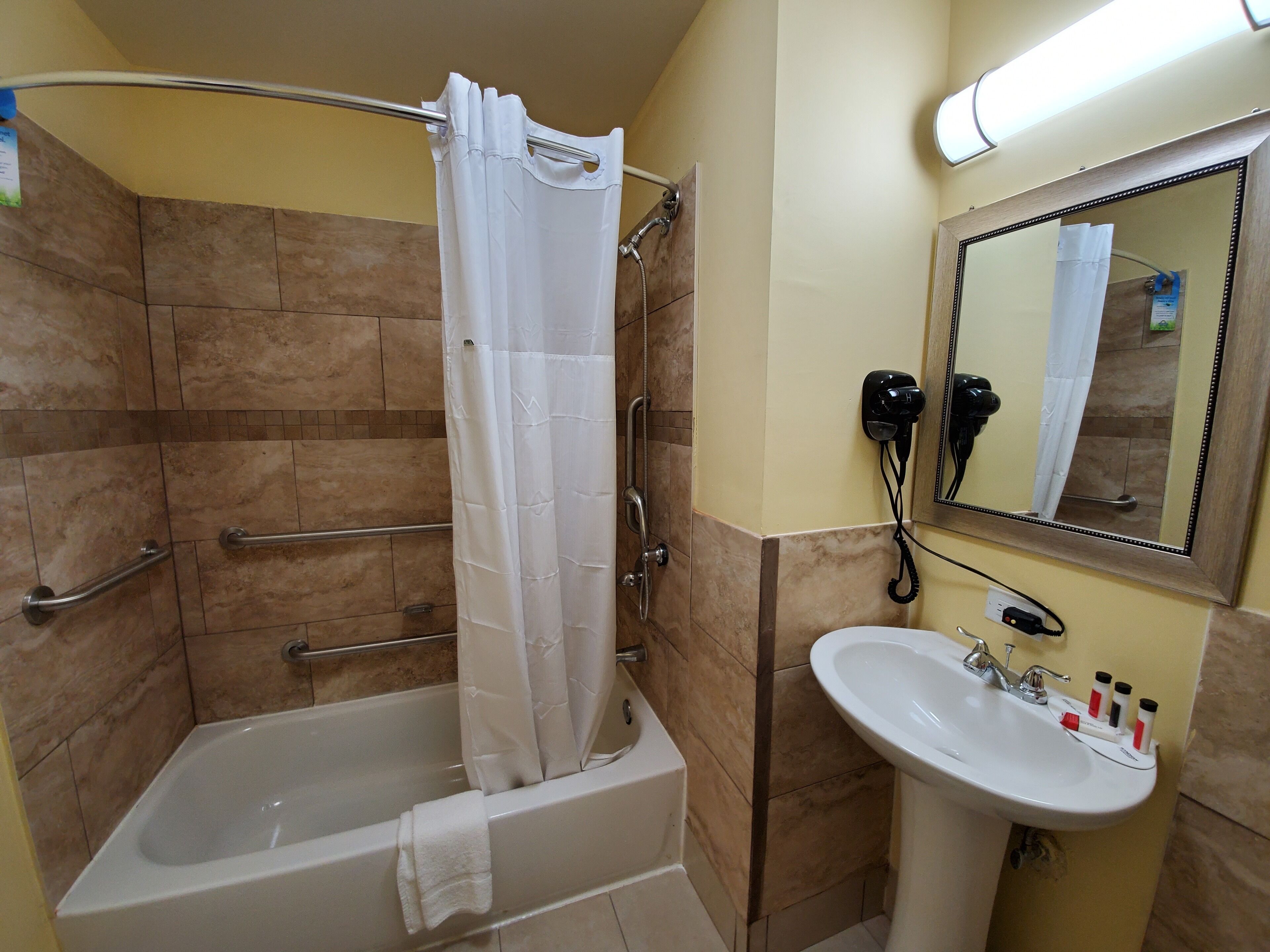 A bathroom with a bathtub, shower, and sink.