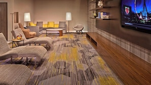 A modern living room with sofas, a coffee table, and a flat-screen TV mounted on the wall.