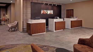 A reception area with three desks, a patterned wall, and a carpeted floor.