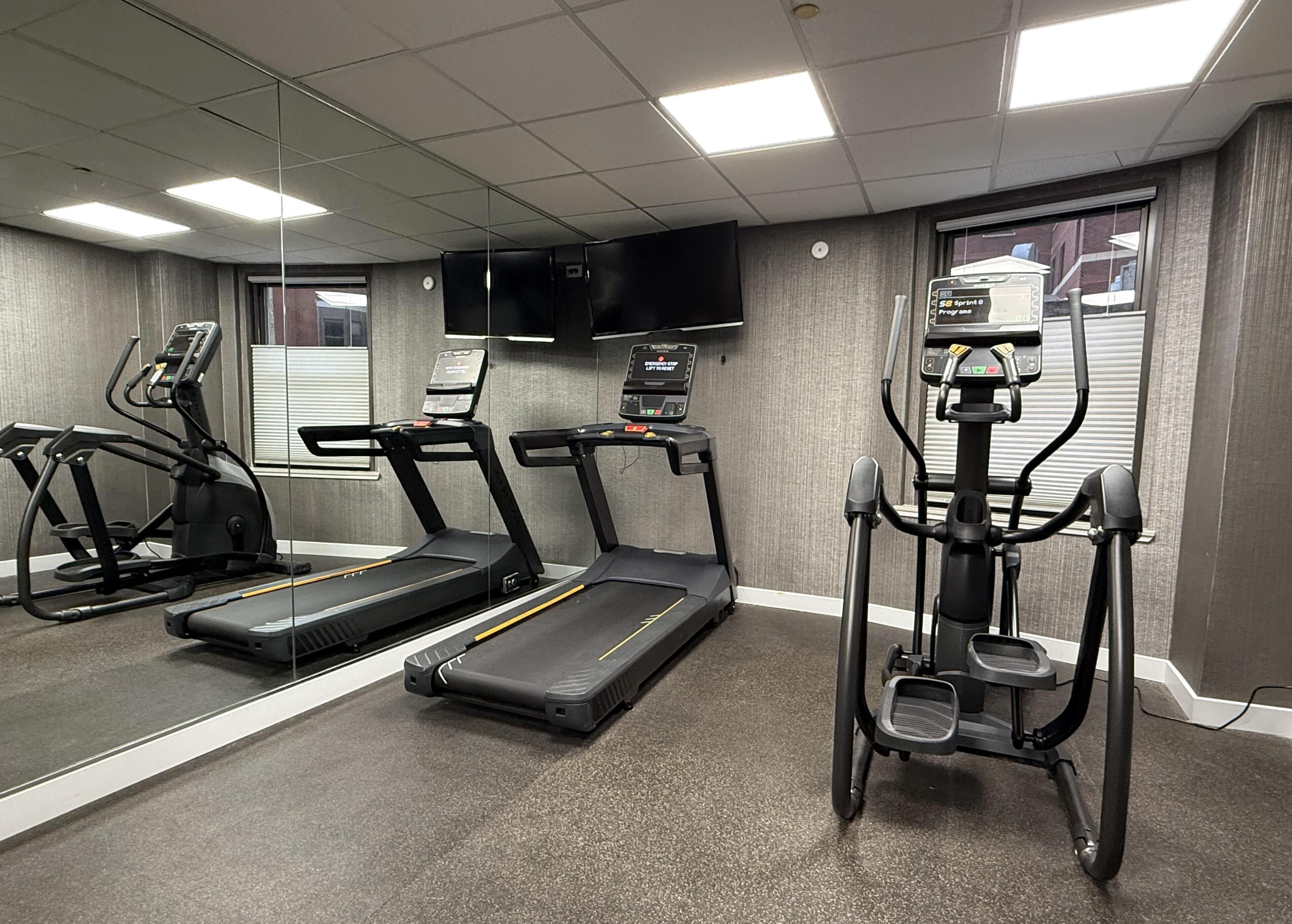A gym with treadmills, an elliptical, and a stair climber.