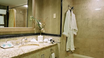 A bathroom with a sink, mirror, and bathtub.