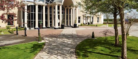 A large building with a central entrance, columns, and a covered walkway.