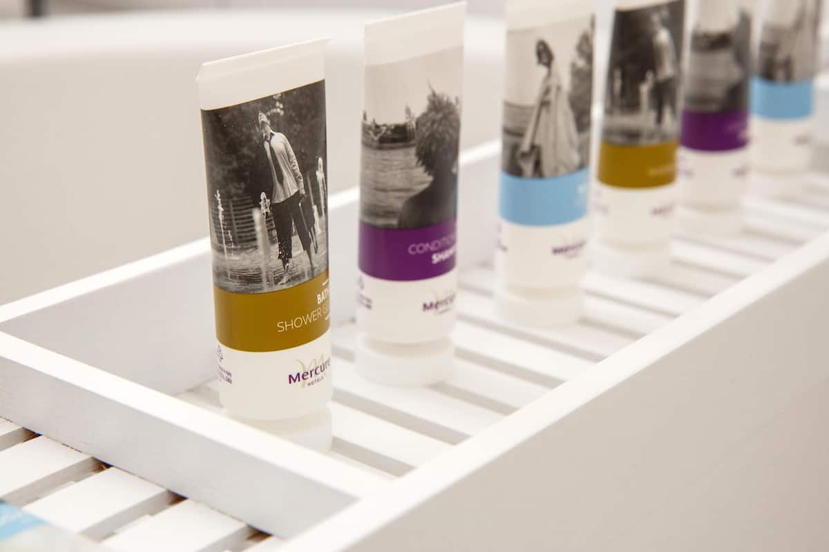 A row of toiletries on a white shelf.