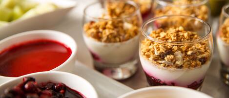 Una bandeja con postres, incluyendo parfait y compotas de fruta.