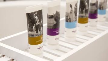 A row of toiletries on a white shelf.