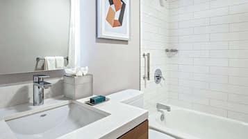 A modern bathroom with a large sink, a bathtub, and a shower.