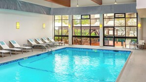 An indoor swimming pool with clear blue water, sunlit by large windows, and surrounded by lounge chairs. - DoubleTree by Hilton Hotel Boston - Westborough (Westborough)