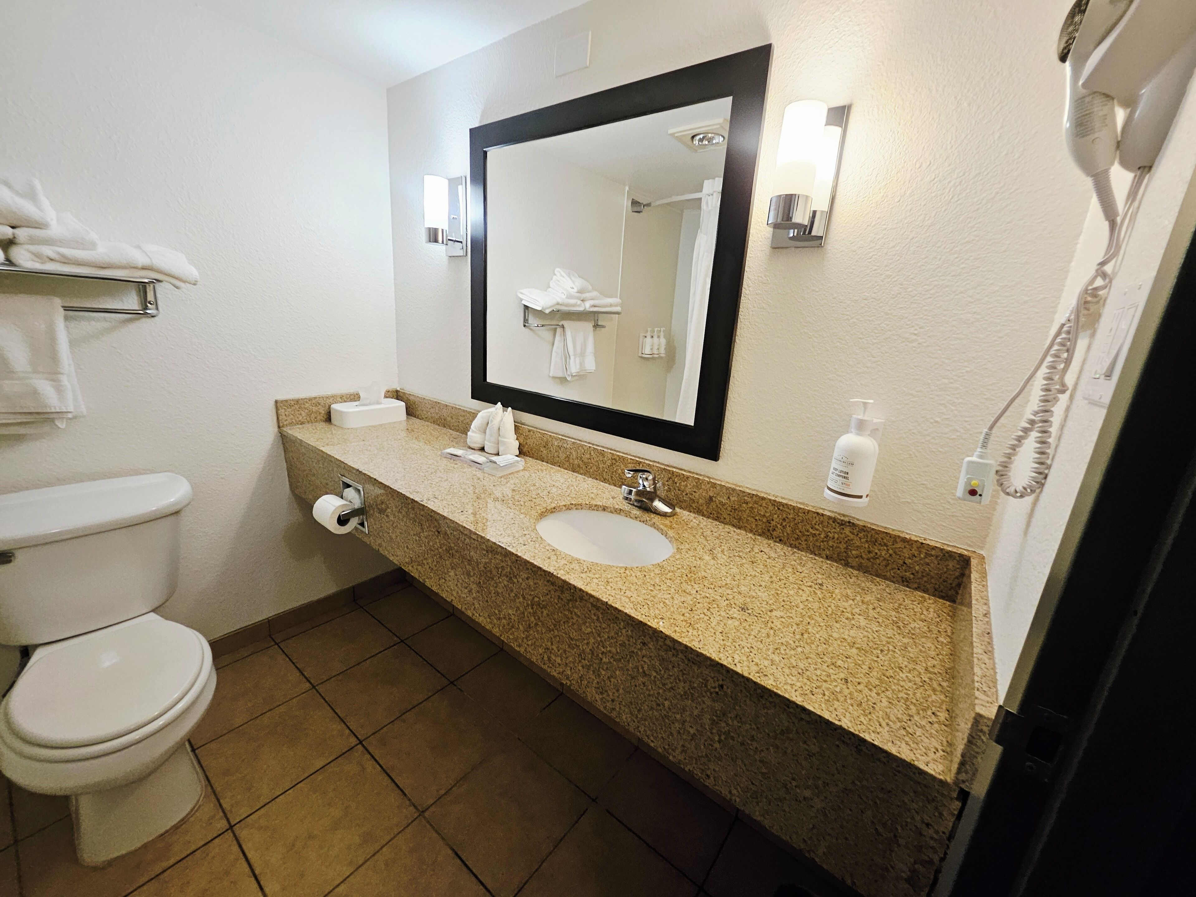 Un baño con inodoro, lavabo y espejo.