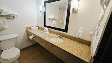 Un baño con inodoro, lavabo y espejo.