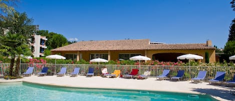 Piscine extérieure en saison, parasols, chaises longues