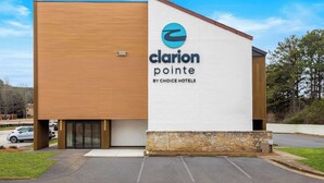 A modern hotel building with a wooden facade and a stone base. - Clarion Pointe Kennesaw Town Center (Kennesaw)