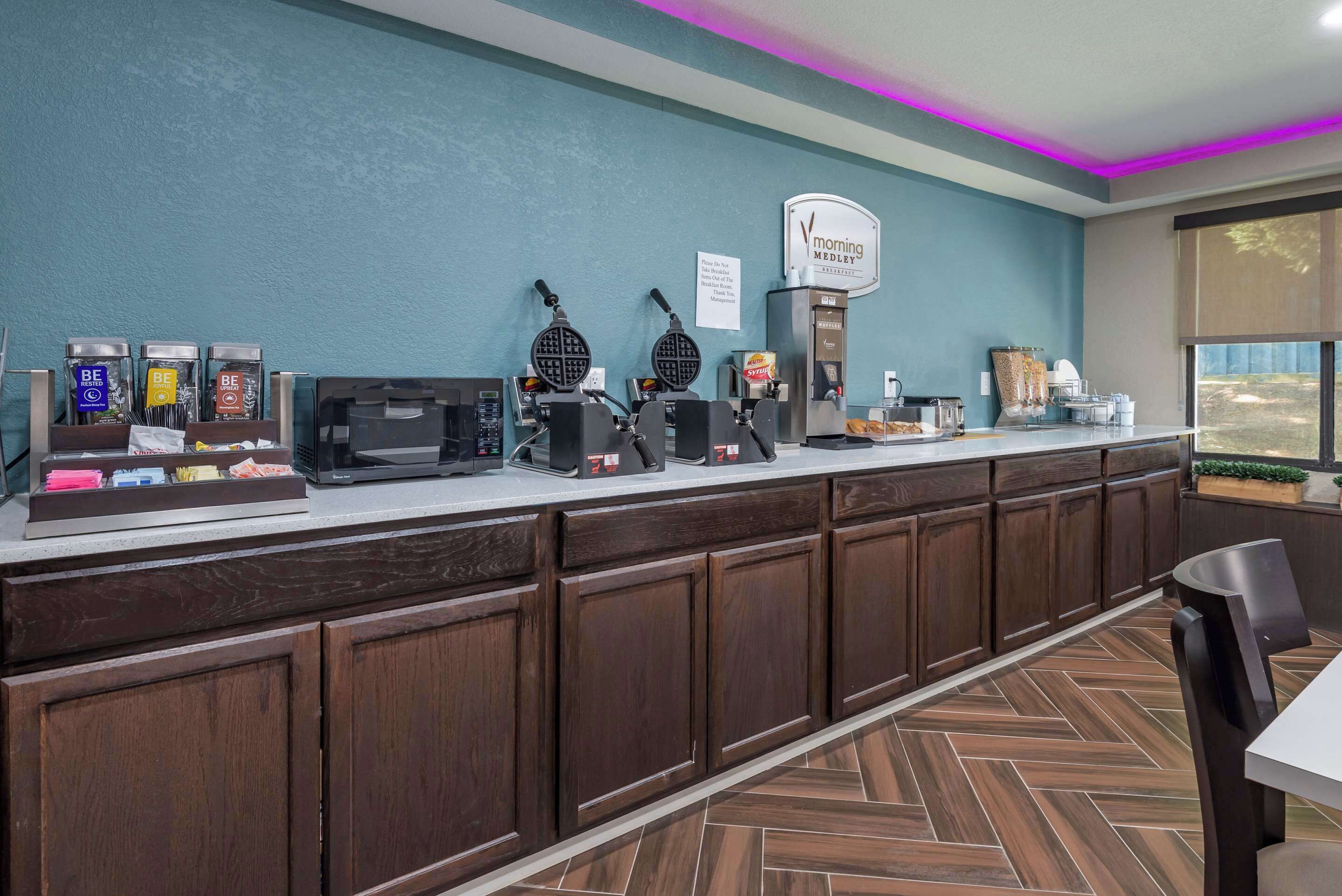 Un buffet pour le petit-déjeuner avec des appareils à gaufres, des machines à café et un panneau indiquant « Mélange matinal ».