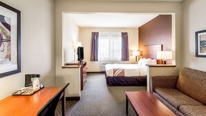 A hotel room with a bed, a sofa, a desk, and a television. - Quality Inn Sheboygan North I-43 (Sheboygan)