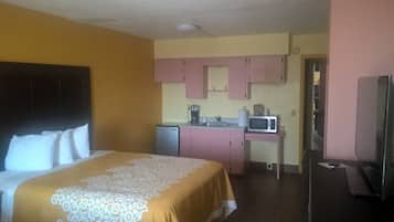 Une chambre d’hôtel équipée d’un lit, d’une kitchenette et d’un téléviseur.
