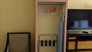 A room with a bunk bed, a chair, a TV, and a shelf with items.