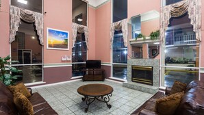 Un salon spacieux avec un canapé en cuir marron, une table basse ronde et une cheminée.