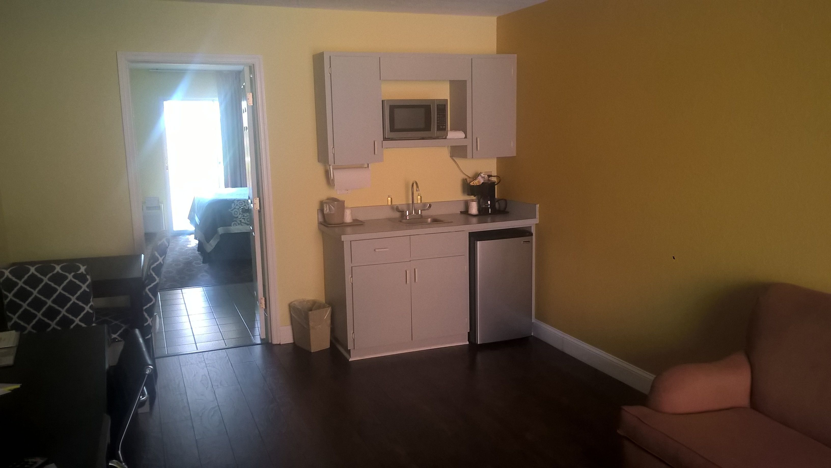 Um espaço compacto com cozinha compacta, área de jantar e quarto.
