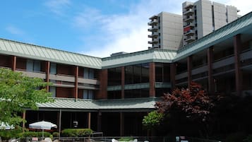 A swimming pool with lounge chairs and a building in the background.