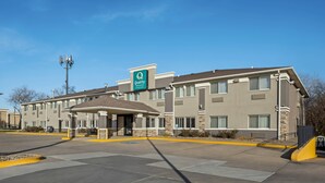 A hotel with a covered entrance, multiple windows, and a sign indicating it is a Quality Inn Express. - Quality Inn & Suites Des Moines Airport (Des Moines)