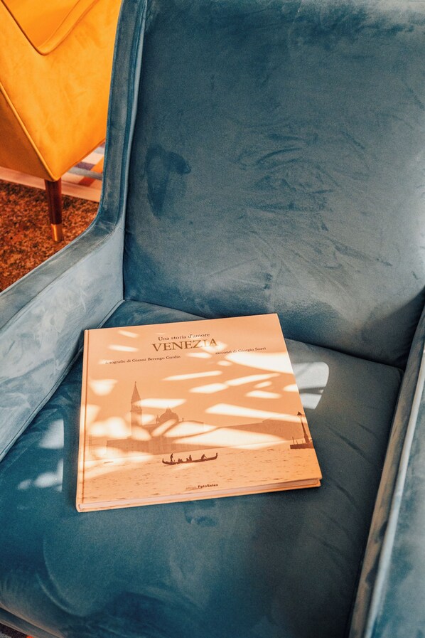 Une chaise bleue sur laquelle est posé un livre intitulé « VENEZIA ».