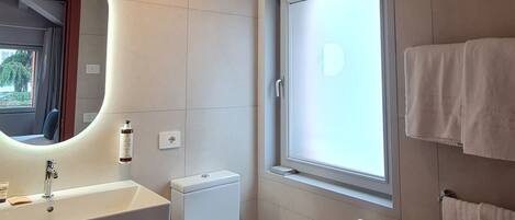 A modern bathroom with a large sink, toilet, and bathtub.