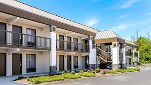 A modern multi-story hotel with balconies, a covered outdoor area, and a landscaped garden. - Farragut Inn & Suites (Farragut)